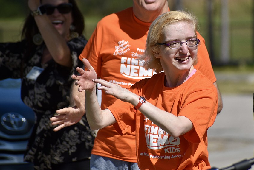 Aktion Club member Carol Aupperle performs with the club during the ribbon cutting ceremony.