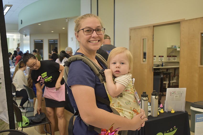 Alisia Dixon and Wyatt Dixon, 1, at the HealthFit Moms in Motion table by Sarasota Memorial Hospital