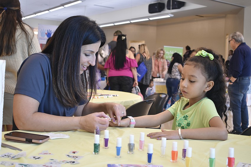 Helen Kuenzner paints the nails of Arianna Vilchez, 7.