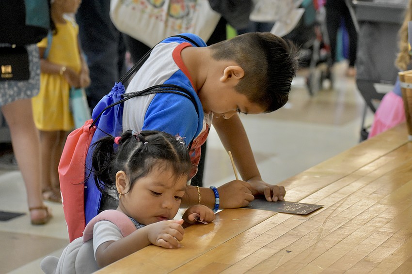Valentina Lopez, 2, and Dylan Lopez, 6, entertain themselves by the room's stage.