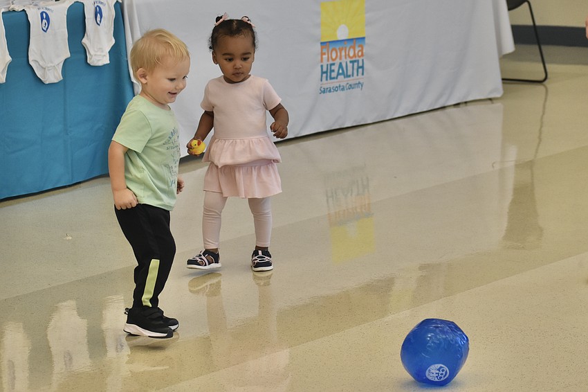 Calico Becker, 1, and Kahina Aridod Ngwa, 1, play ball together.