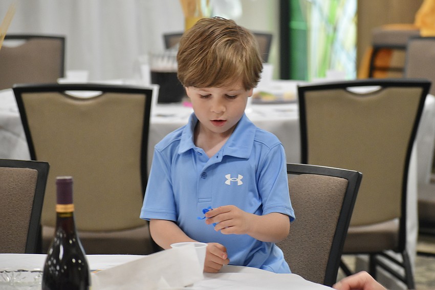 Dylan Albright, 5, discovers a toy frog gift as he sits down at his table.
