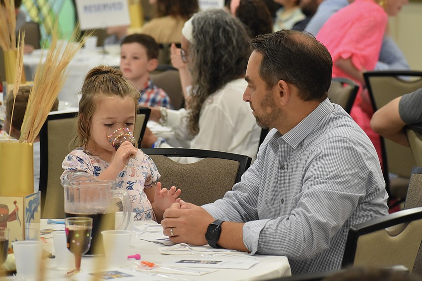 Novalee Golen, 5, drinks the grape juice as she sits beside Michael Golen.