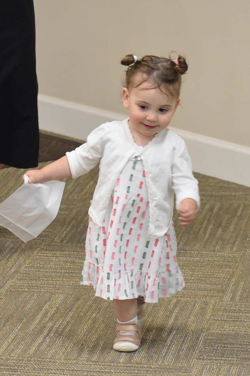 Maya Shefrin, 1, enjoys the hunt for the 10 plagues hidden around the room.