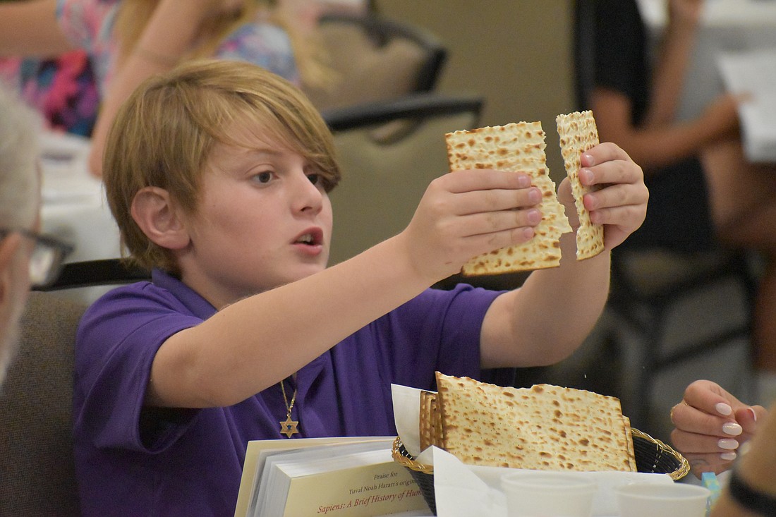 Flynn Berman, 11, breaks the matzah.