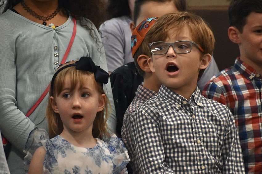 Reagan Spell, 4 and Brody Gates, 5, sing with the other children on stage.