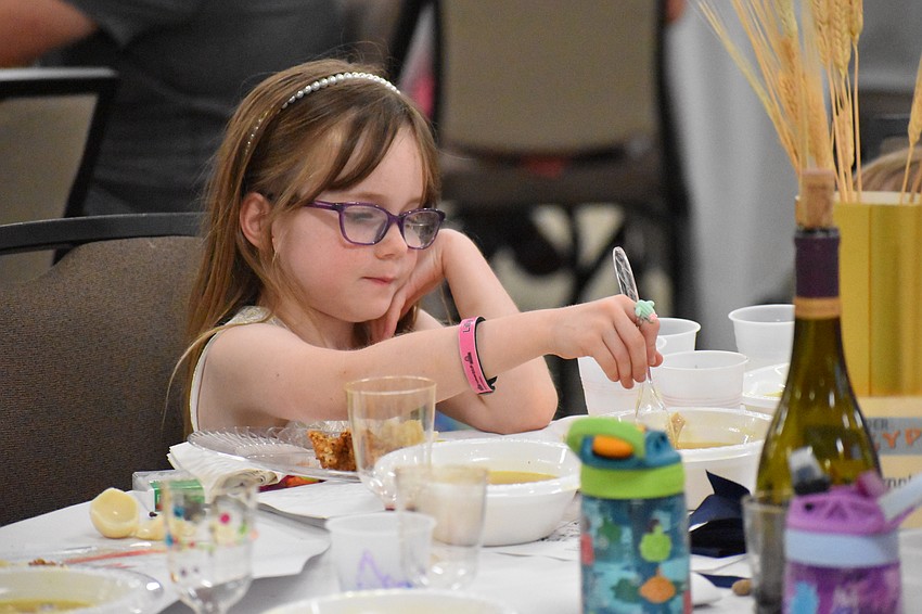 Lilly Spell, 6, eats the soup during the feast.