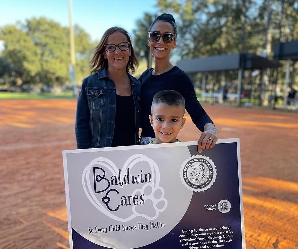 Amy Rodriguez, Baldwin Cares chairperson and softball player, poses with her son and Terri Poulos, Baldwin Park Elementary School Parent Teacher Association president.