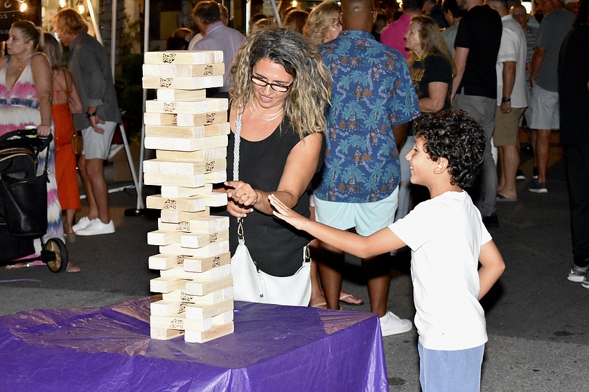 Debra Braunstein and Lukas Braunstein, 8, play a game of Jenga.