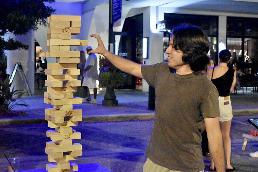 Anghelo Acosta makes a precise move in Jenga.