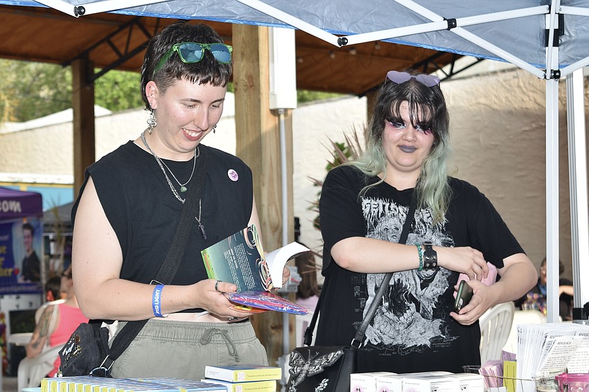 Audrey Meyer and Zoe Toundas browse the items on offer at the table of The Players Centre.