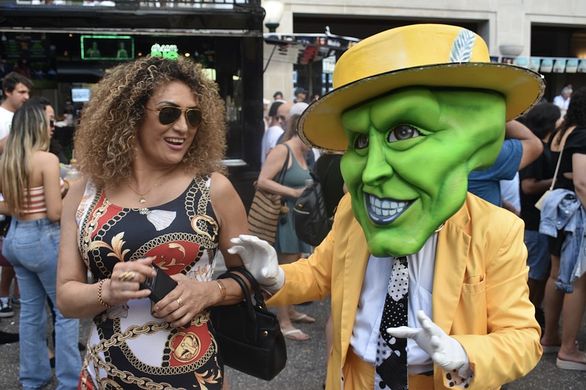 Lilliana Williams is invited to dance to the rumba beat by a performer from Karen's Hora Loca dressed in a costume based on 