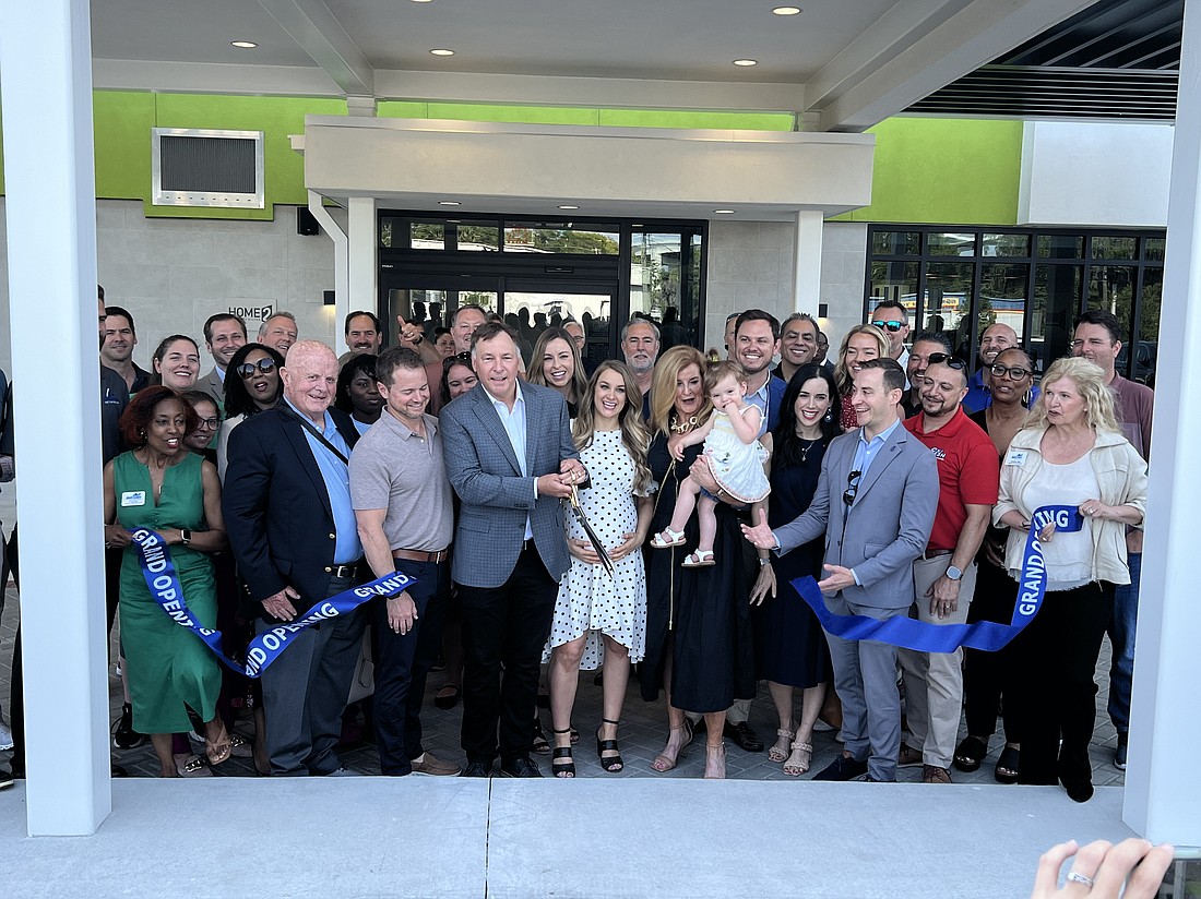Kelco Management and Development Inc. President Kelley D. Slay holds the scissors after cutting the ribbon for the new Home2 Suites by Hilton Jacksonville Downtown at 600 Park St.