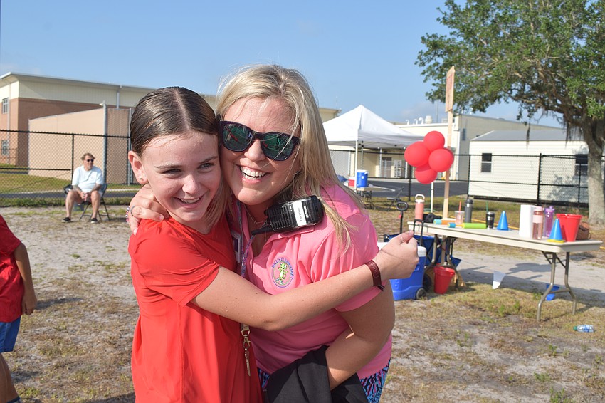 Fifth grader Aubri Darpino hugs her mother, Courtni Darpino, the student support specialist. 
