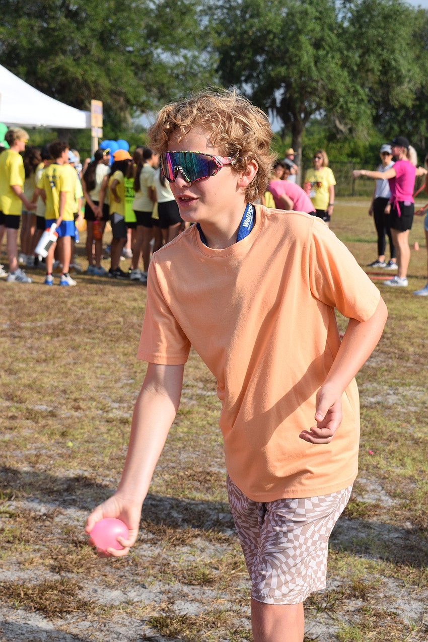 Ffith grader Landon Finch tosses a water balloon to his partner after a successful catch. Unfortunately, the water balloon popped, and they were out of the competition.