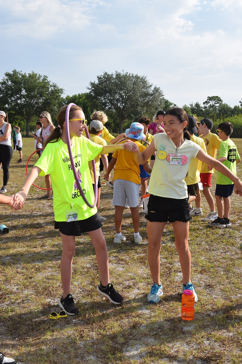 Fifth grader Jelena Konatar moves the hula-hoop through her body after getting it from fifth grader Miranda Villalobos.