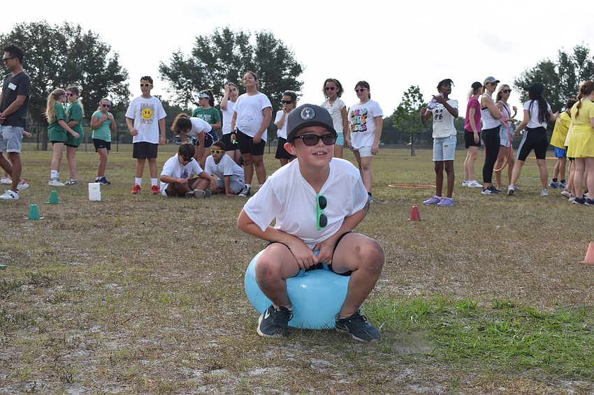 Fourth grader Graham Lough tries his best to make it to the end to keep his team going in the bouncy ball relay. 