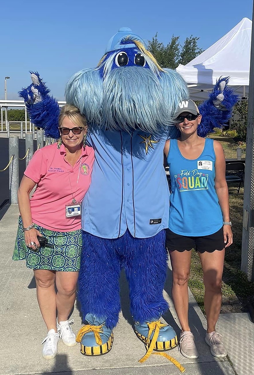 Katie Fradley, the assistant principal, and Colleen Laughlin get their photo taken with Raymond from the Tampa Bay Rays.