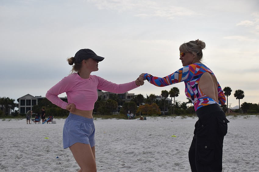 Sami Hobbs and Sonja Kaiser practiced their kickboxing skills during a mirroring exercise in the mother-daughter workout beach boot camp.