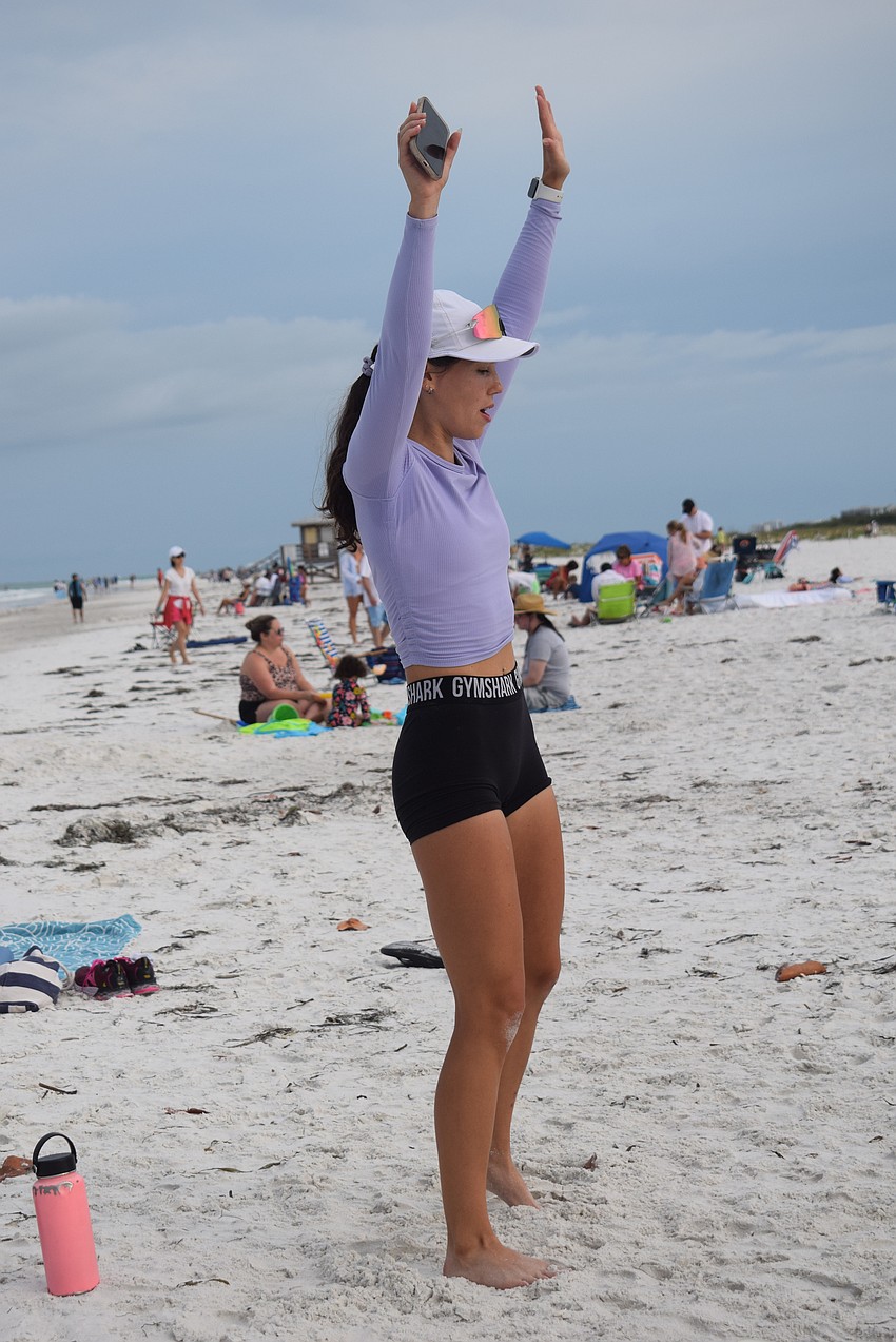 Kathryn Adelman leads a cool-down after teaching her first beach workout class.
