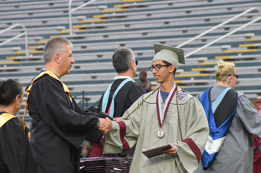 Richard Tatem, a member of the School Board of Manatee County, congratulates Braden River High's Giovanni Sannuto.