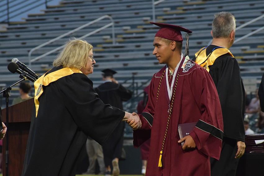 Mary Foreman, a member of the School Board of Manatee County, congratulates Braden River High's Jeremiah Gonzalez.