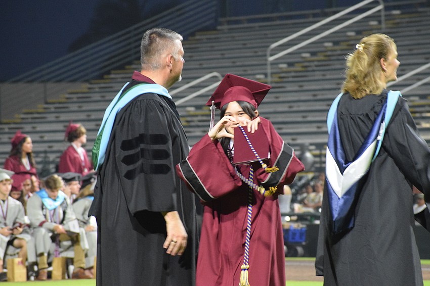 Braden River High graduate Hayleigh Vuong makes her hands into the shape of a heart to show love for people in the audience.