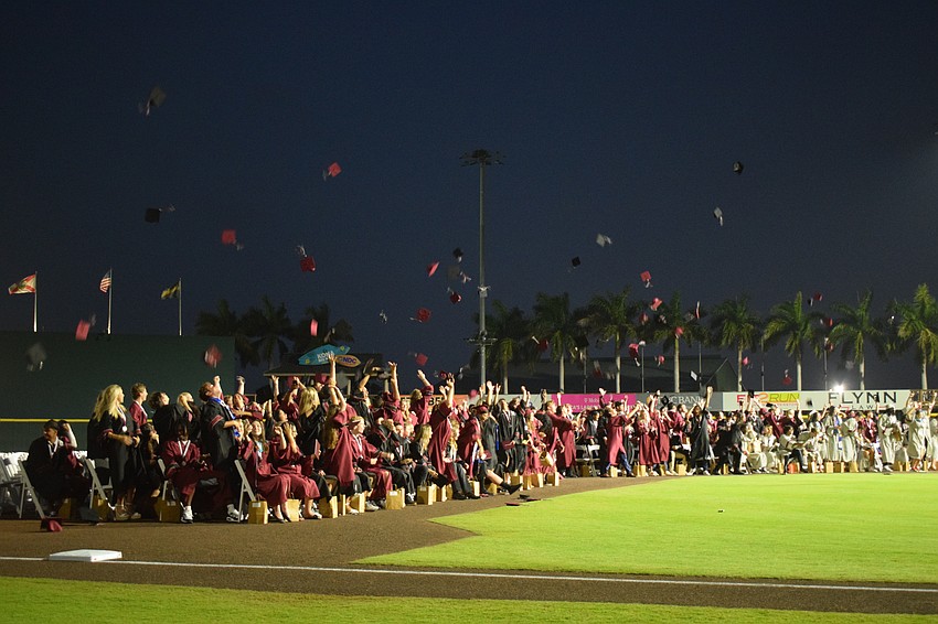 After turning their tassels, Braden River High graduates throw their caps in the air.