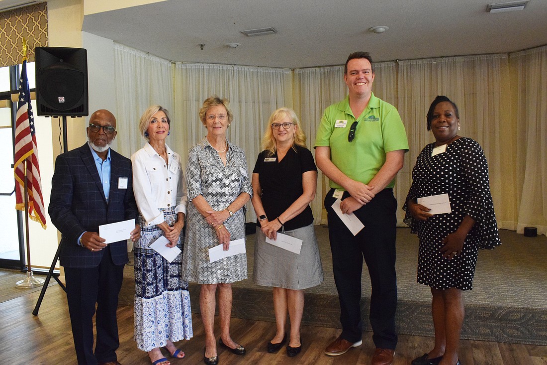 Charles Shortridge, Rosemary McMullen, Caroline Lawrence, Char Young, Jonathan Evans and April Glasco accept grants from the Palm Aire Women's Club on behalf of their respective nonprofits.