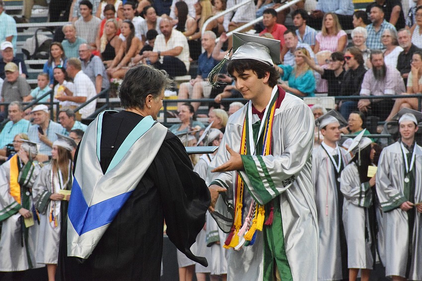 Jeannie Galindo, an assistant principal at Lakewood Ranch High School, congratulates Andrew Boudreau and hands him his diploma.