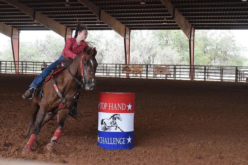 Sareece Coons has her horse hang tight around the barrel to get through the barrel race faster.