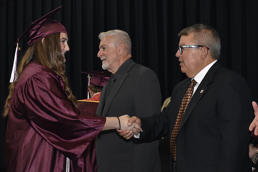 Sabrina Zabalaga shakes hands with school board members Tom Edwards and Tim Enos