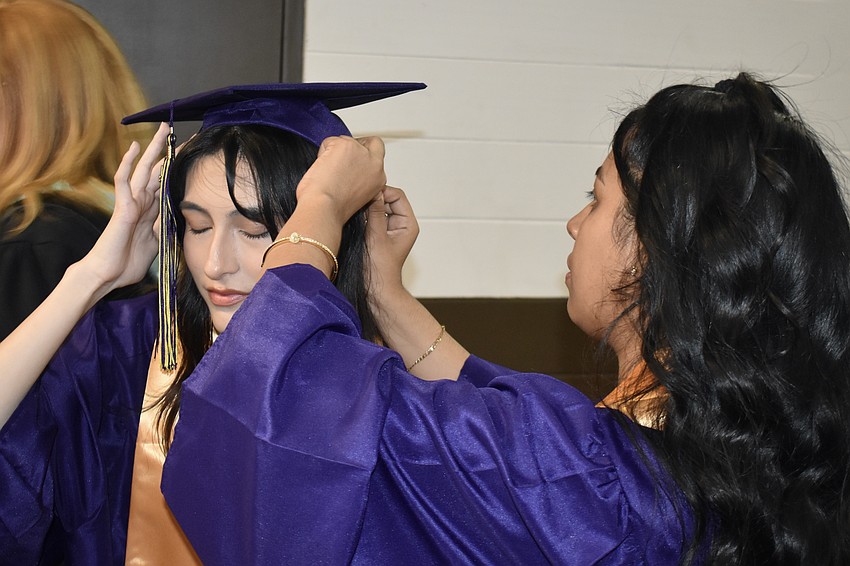 Jacqueline Flores has her cap adjusted by Sailey Flores.