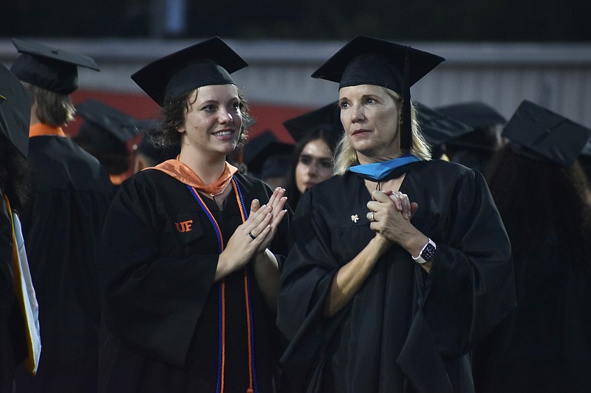 Rachel and Andrea Missey, mother and daughter English teachers, watch the procession of the students.