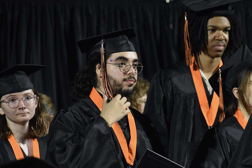 Axell Fraga adjusts his tassel as he heads across the stage.