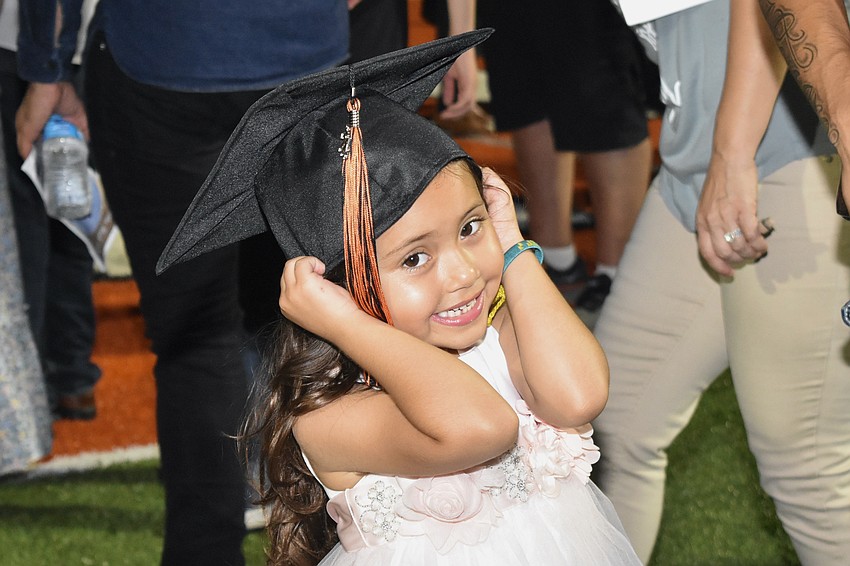 Janae Lopez-Catalan, 5, tries on the cap of her aunt, graduate Evelyn Catalan.
