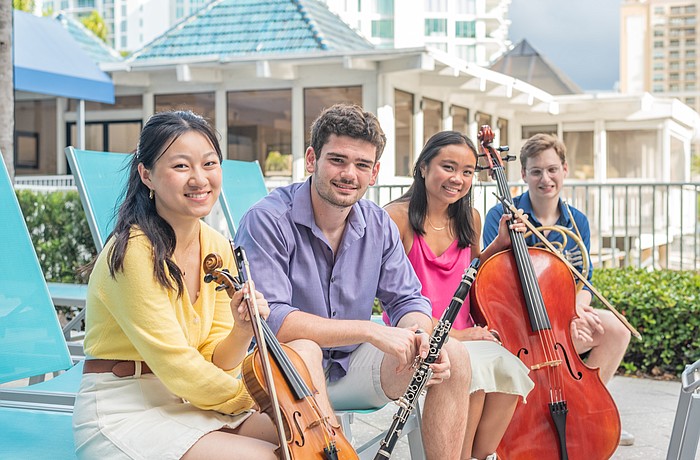 Sarasota Music Festival 2023 fellows Ellen Hayashi, Ray Wyant, Melanie Chen and Daniel Itzkowitz relax with their instruments.