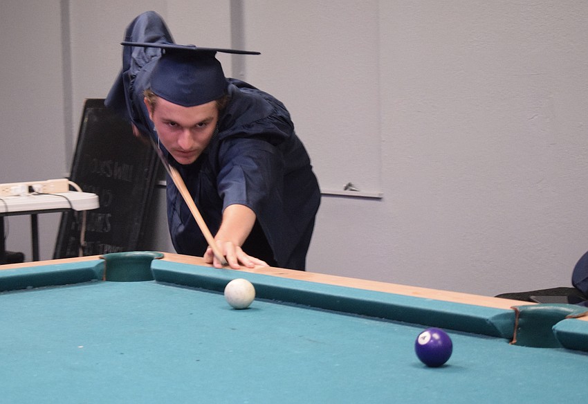 Axl Aparicio-Jerro plays pool before the graduation ceremony.