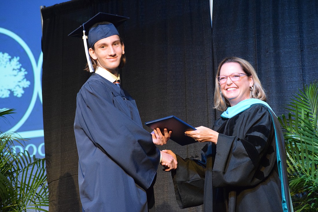 Ryan Abernathy is the first to accept a diploma for the Class of 2024 from Head of School Deb Otey.