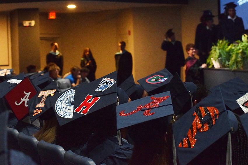 Graduates decorate their caps to show where they are headed next school year.