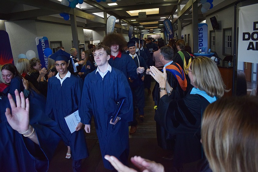 Graduates make their way out of Bayside Church as The Out-of-Door Academy faculty and staff cheer for them.