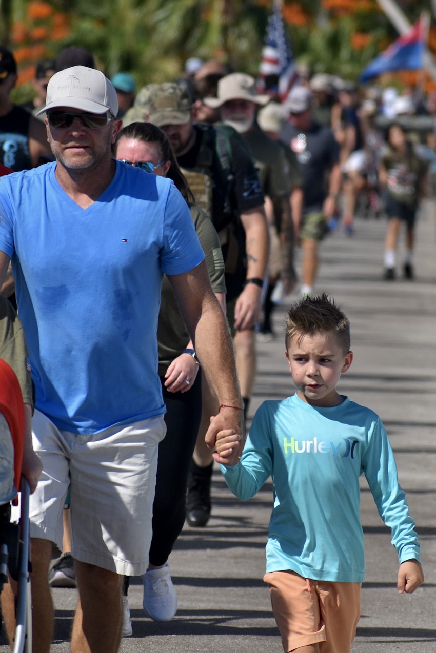 Sebastian Jasinski and Liam Jasinski, 7, walk the Ringling Causeway together.