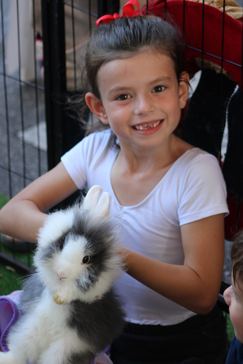 Lakewood Ranch 6-year-old Ella Dean enjoys a petting zoo rabbit during the block party before the Tribute to Heroes Parade.