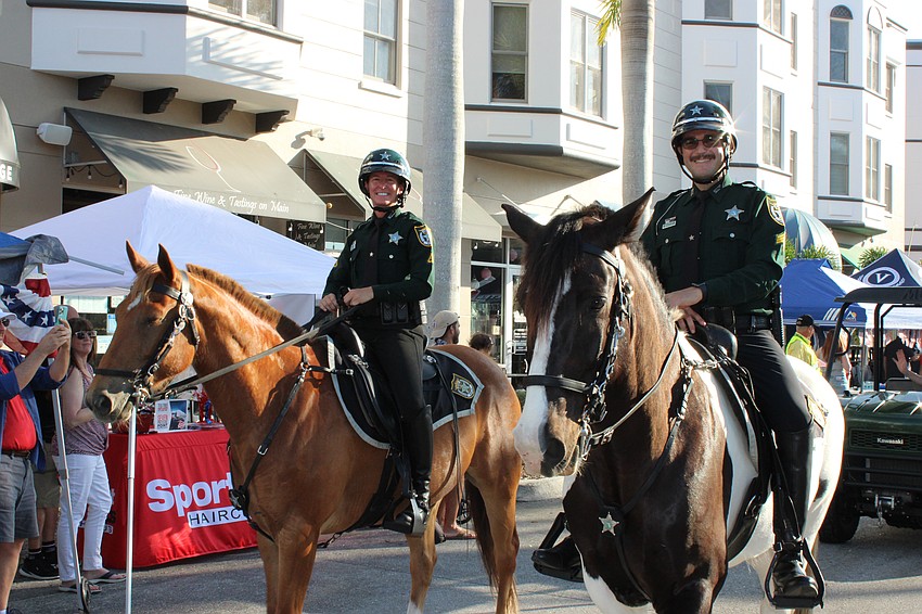 Lauren Bradley and Zach Bradley, mounted officers for the Manatee County Sheriff's Office, make their way down Lakewood Main Street during the Tribute to Heroes Parade.