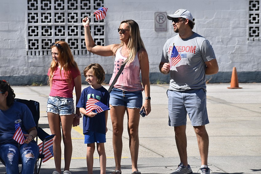Raine Allen, 11, Lennox Allen, 7 and Mia and Britt Allen greet the oncoming vehicles.