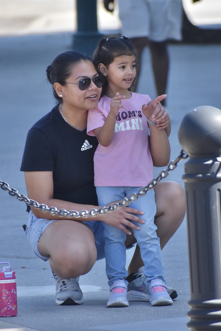 Iveth Castillo and Francesca Castillo, 3, watch the parade.