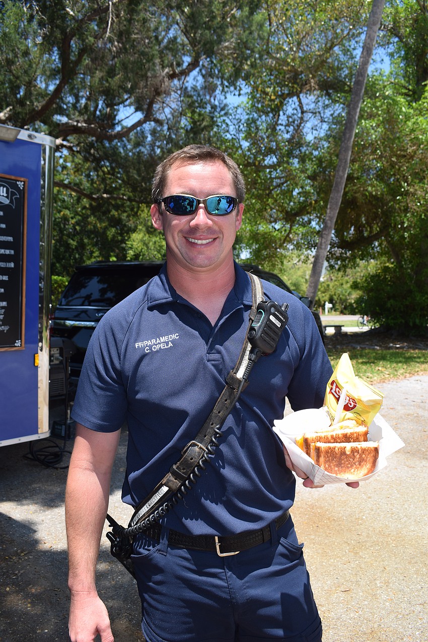 Chase Opela enjoys a free grilled cheese after coming back from a call with the Longboat Key Fire Department.