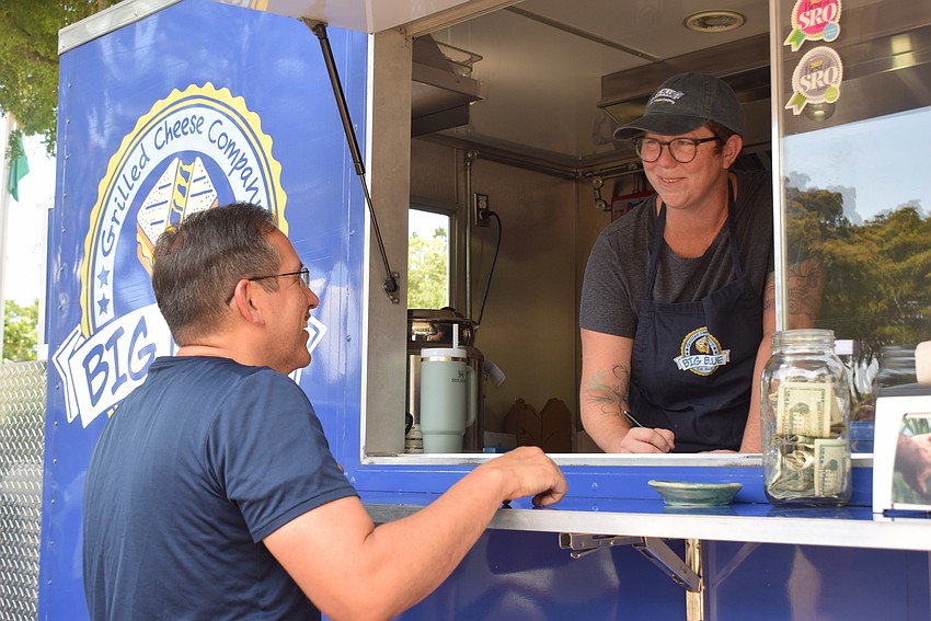 Public Works Director Isaac Brownman orders a grilled cheese from Brenna Foster with the Big Blue Grilled Cheese Company food truck.