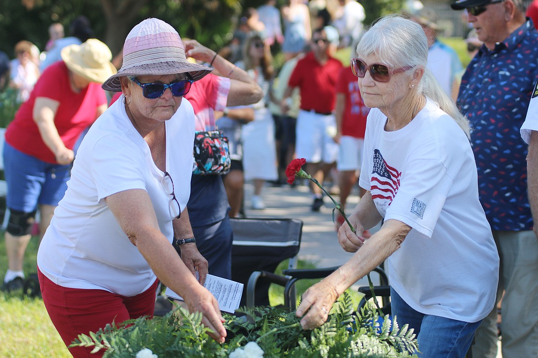 People lay flowers in honor of fallen veterans during Ormond Beach's Memorial Day Remembrance Service on Monday, May 27. Photo by Jarleene Almenas