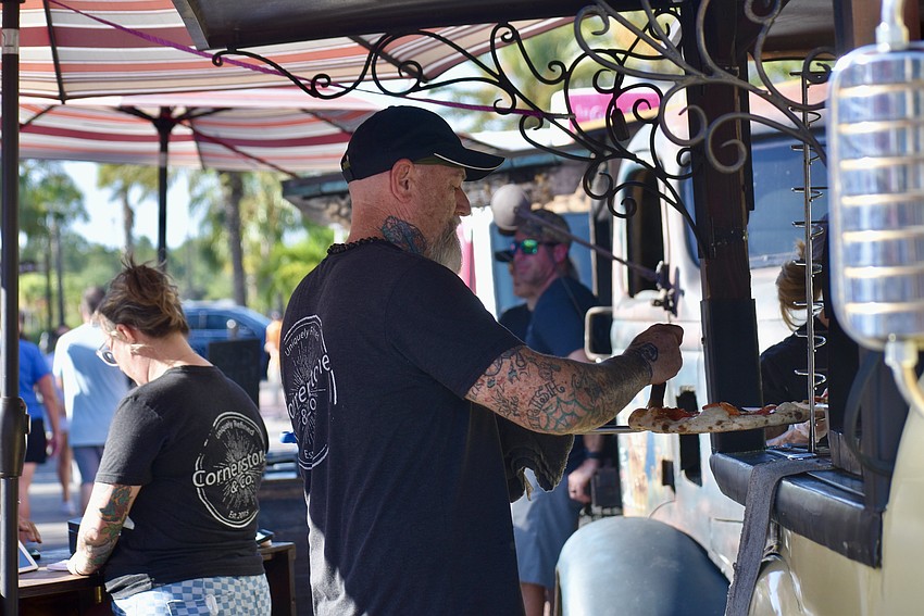 Ryan Kelly pulls a pepperoni pizza out of the wood fired oven in the Cornerstone and Company truck.